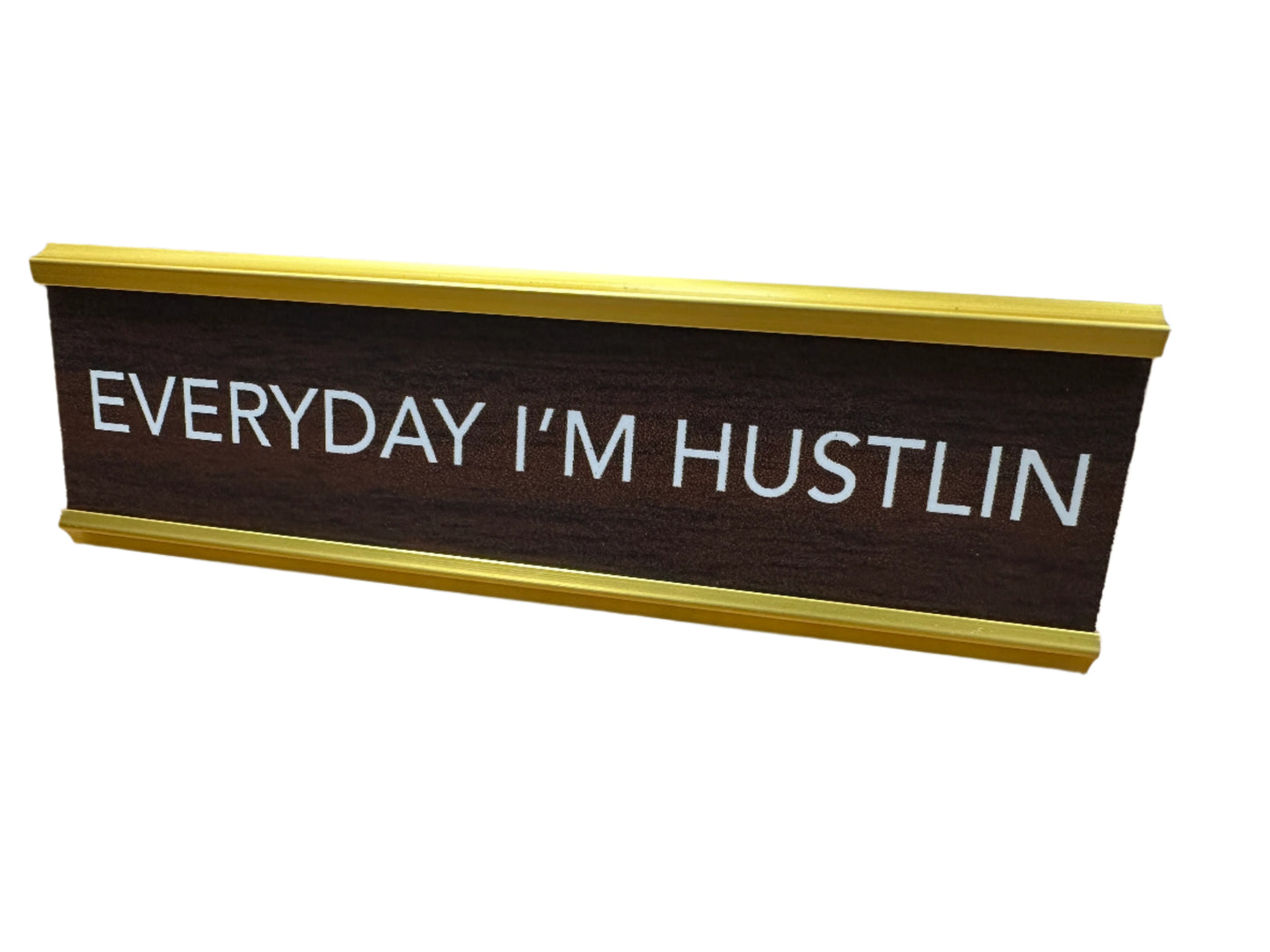 Sign that reads 'Everyday I'm Hustlin' on a wooden surface.