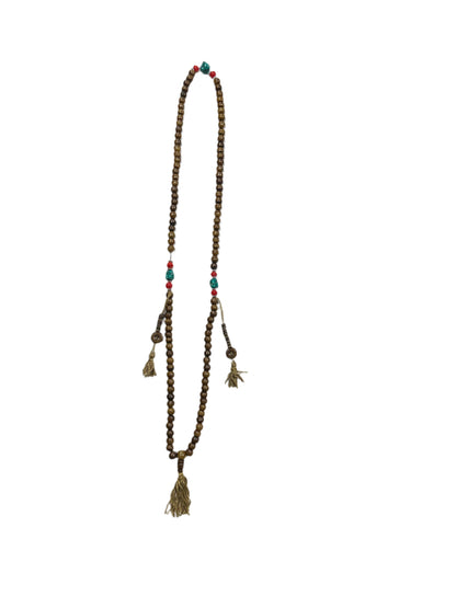 Wooden beaded necklace on a white sheet of paper with packaging in the background.