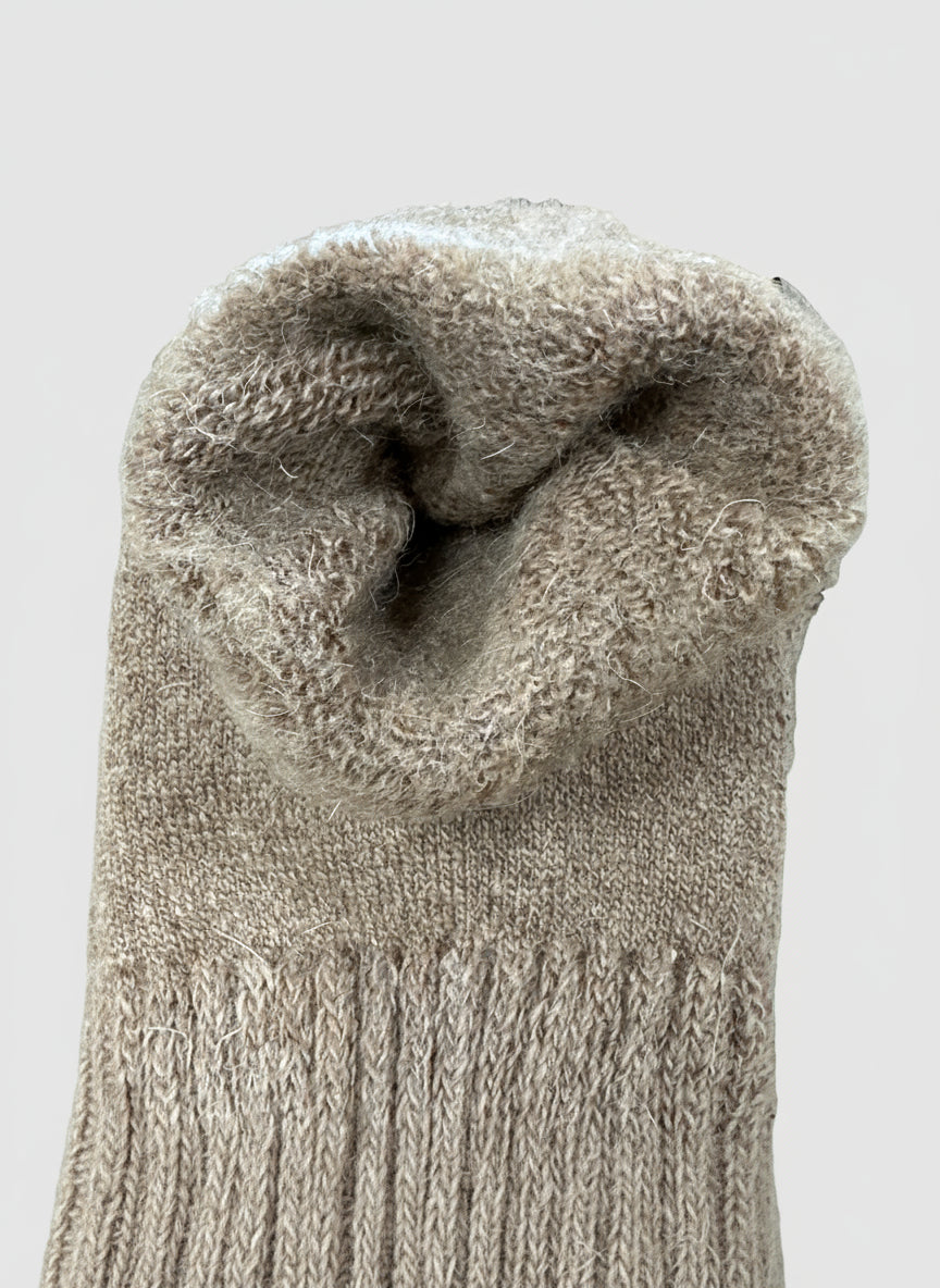 Close-up of a textured brown sock on a surface with a patterned background